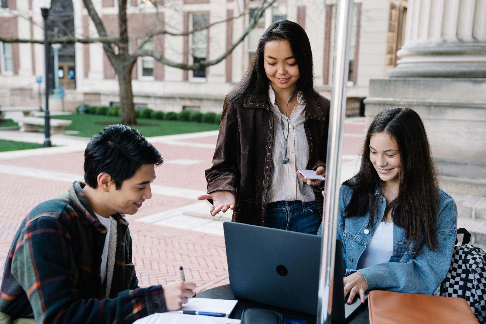 Stock photograph of university students discussing a project on campus